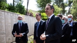 FILE - Greek Prime Minister Kyriakos Mitsotakis, center right, visits The Righteous Among the Nations Memorial during a visit to the Yad Vashem Holocaust Museum in Jerusalem, June 16, 2020. 