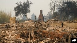 A chimney is left standing amid the ruins of a wildfire-ravaged home enveloped by the CZU August Lightning Complex Fire, Aug. 21, 2020, in Bonny Doon, Calif.