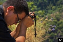 Lebanese priest Hani Tawk prays outside the Qannoubine Monastery, hidden deep in the Kadisha Valley, a holy site for Lebanon's Maronite Christians, in Bcharre, Lebanon, on July 22, 2023.