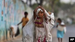 FILE - A girl collecting reusables walks in Hyderabad, India, March 9, 2016. Child labor is widespread in India; an estimated 13 million children work, yet many NGOs think the actual figure could be far higher.