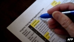 This illustration photo shows a Virginia resident filling out an application to vote by mail ahead of the November Presidential election, on Aug. 6, 2020 in Arlington, Virginia. 