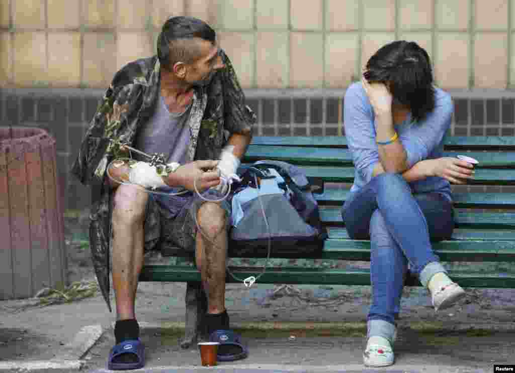 A soldier of the Ukrainian Army, who was injured during the fighting against separatists in Eastern Ukraine, talks to a relative at the hospital in Kyiv, Sept. 2, 2014.