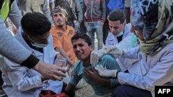 Le personnel médical soigne un Palestinien blessé lors des tirs des forces de sécurité israéliennes, Gaza, 31 mars 2018.