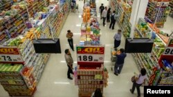 FILE - People shop in a supermarket inside a department store in Bangkok.
