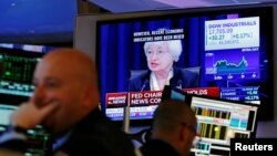 Traders work as Federal Reserve Chair Janet Yellen speaks on a television above the floor of the New York Stock Exchange (NYSE) shortly after the opening bell in New York City, June 15, 2016