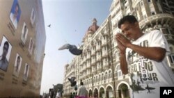 A man pays homage in front of portraits of police officers killed in the Mumbai terror attack outside the Taj Mahal Palace hotel, one of the sites of the attack, on the second anniversary of the attack in Mumbai, 26 Nov 2010