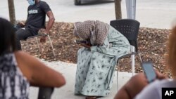 Job seekers wait outside a Workforce Solutions office in Omaha, Neb., July 23, 2020, as the virus pandemic's resurgence caused the number of Americans seeking unemployment benefits to rise last week for the first time in nearly four months. 
