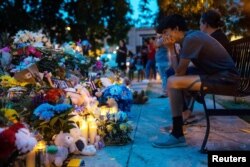 Para pelayat memberikan penghormatan pada peringatan 21 orang yang tewas dalam penembakan massal di Robb Elementary School, di Uvalde Town Square di Uvalde, Texas pada 1 Juni 2022. (Foto: Lucas Boland/USA TODAY NETWORK via REUTERS)