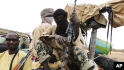 Militiamen from the Ansar Dine Islamic group sit on a vehicle in Gao in northeastern Mali, June 18, 2012. 