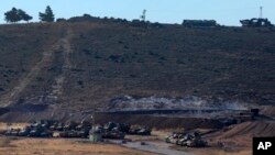 Turkey's forces' tanks and vehicles hold positions close to the border with Syria, near the town of Reyhanli, Oct. 9, 2017. 