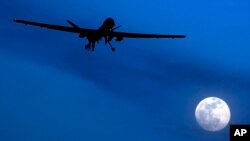 FILE - An unmanned U.S. Predator drone flies over Kandahar Air Field, southern Afghanistan, on a moon-lit night, Jan. 31, 2010.