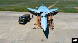In this photo released by Russian Defense Ministry Press Service on May 21, 2024, a Russian crew prepares a Tu-22M3 bomber for a training mission as part of drills to train the military for using tactical nuclear weapons at an undisclosed location in Russia.