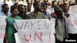 Sudanese protesters hold signs during a demonstration in Tel Aviv against the deportation of migrants from South Sudan, June 10, 2012. 