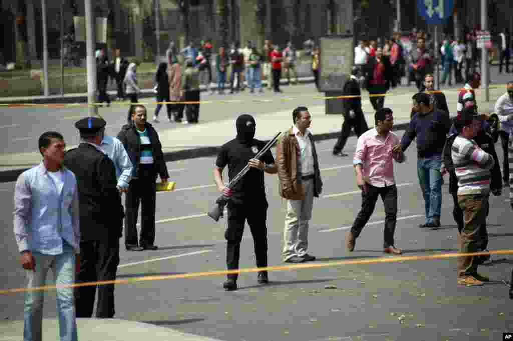 Security forces stand guard at the scene after multiple explosions hit the area outside the main campus of Cairo University, April 2, 2014. 