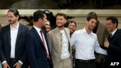 French newly elected member of parliament for La France Insoumise (LFI) from the leftist coalition New Popular Front Raphael Arnault, center, and colleagues arrive to France's National Assembly in Paris on July 9, 202