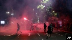 Protesters clash with riot police on the steps of the Serbian parliament during a protest in Belgrade, Serbia, July 10 2020.