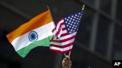 FILE - A man holds the flags of India and the U.S. at an India Day Parade in New York City, Aug. 16, 2015.
