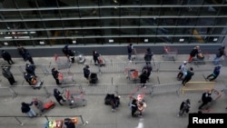 Des acheteurs pratiquent la distance sociale pendant qu'ils attendent avec leurs chariots pour entrer dans un magasin Target à Manhattan lors de l'épidémie de la maladie à coronavirus (COVID-19) à New York, New York, États-Unis, le 1er avril 2020. REUTERS / Brendan Mcdermid