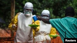 Medical staff working with Medecins sans Frontieres bring food to patients isolated at a treatment center in Kailahun, Sierra Leone, July 20, 2014.