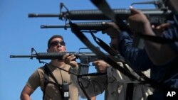 Tentara Angkatan Laut Amerika menembakkan senapan serbu M-16 saat melepas kapal induk USS Arleigh Burke dalam pelayaran ke Kenya, 24 Juni 2009 (Foto: dok). 