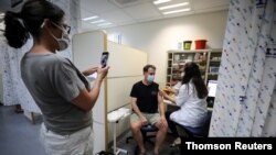 이스라엘 의료진이 현지 주민에게 신종 코로나바이러스 백신 부스터 샷을 접종하고 있다. 