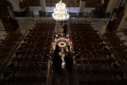 Greek Orthodox priests hold aloft the bier depicting Christ's preparation for burial during the Good Friday procession of the Epitaphios, held without worshippers in an empty church in Thessaloniki, Greece, during a lockdown April 17, 2020.