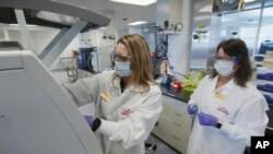 FILE - In this May 2020 photo provided by Eli Lilly, researchers prepare cells to produce possible COVID-19 antibodies for testing in a laboratory in Indianapolis. The drug company says it has asked the U.S. government to allow emergency use of an experim