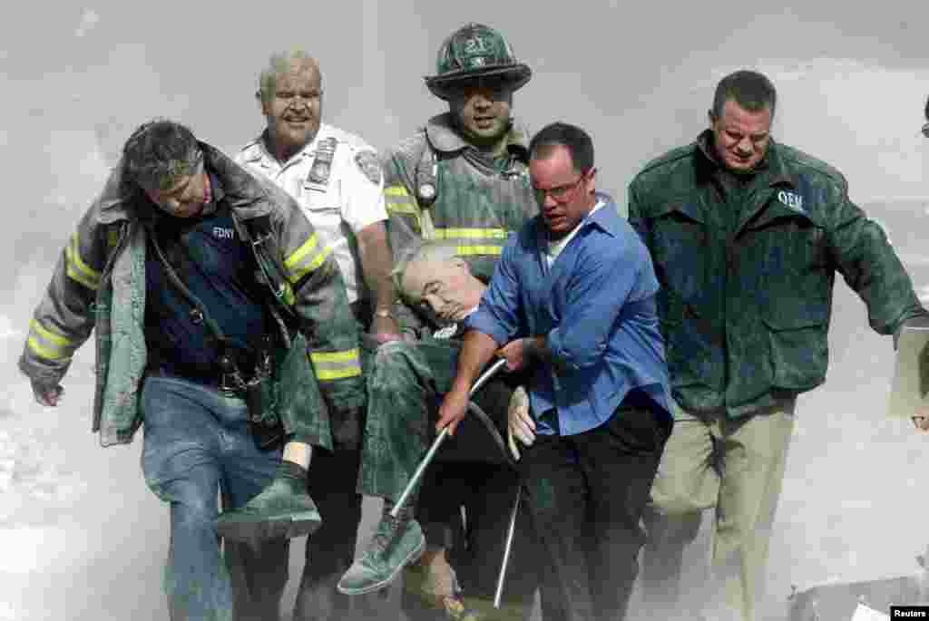 Un homme mortellement blessé est porté par une équipe de secouristes à New York, le 11 septembre 2001.