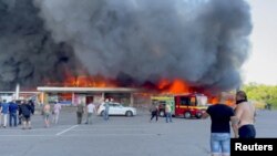 De la fumée s'élève d'un centre commercial touché par une frappe de missile russe, à Kremenchuk, en Ukraine, le 27 juin 2022. 