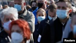 Arhiva - Ljudi noseći zaštitne maske čekaju u redu za vakcinaciju, na Beogradskom sajmu, Beograd, 27. marta 2021. (Foto: AP, Darko Vojinović)