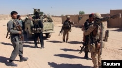 Afghan Special Forces and policemen prepare themselves for battle with the Taliban on the outskirts of Lashkar Gah capital of Helmand, Afghanistan, Oct. 10, 2016. 