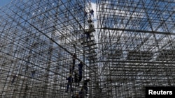 Workers are pictured at the construction site of the beach volleyball venue for 2016 Rio Olympics on Copacabana beach in Rio de Janeiro, Brazil, June 9, 2016. 