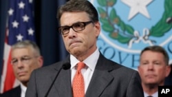 德克萨斯州和州长里克•佩里在记者会上回答提问。（2014年7月21日）