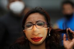 A street vendor wearing a mask to protect herself from the spread of the new coronavirus attends a June 11, 2020, protest in Mexico City demanding the resumption of economic activities.