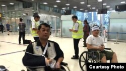 លោក​ ញ៉យ ចំរើន ​តំណាង​រាស្ត្រ​មណ្ឌល​កំពង់ចាម​ (ឆ្វេង) និង​លោក​ គង់ សភា​ (ស្តាំ) តំណាង​រាស្ត្រ​ខេត្ត​ស្វាយរៀង​ នៅ​ក្នុង​កៅអី​រុញ​​បាន​មក​ដល់​អាកាសយានដ្ឋាន​មួយ​នៅ​រាជធានី​បាងកក​​ប្រទេស​ថៃ កាល​ពី​​ថ្ងៃ​​អង្គារ​ទី​២៧ ខែ​តុលា ឆ្នាំ​២០១៥ នៅ​ក្រោយ​​ពេល​​​ពួក​លោក​ត្រូវ​បាន​​បាតុករ​វាយ​ទាត់​ធាក់​នៅ​ខាង​ក្រៅ​បរិវេណ​​រដ្ឋសភា​ជាតិ​ក្នុង​រាជធានី​ភ្នំពេញ​កាល​ពី​ថ្ងៃ​ច័ន្ទ​។​​ (ផ្តល់​ដោយ​លោក ញ៉យ ចំរើន)