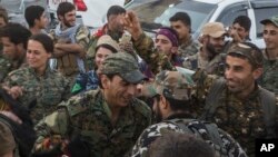 anggota Pasukan Demokratik Suriah (SDF) menarikan tarian tradisional 'Dabka" dalam sebuah perayaan di depan stadium lokasi pertahanan terakhir tentara ISIS, di Kota Raqqa, Suriah, 20 Oktober 2017. 