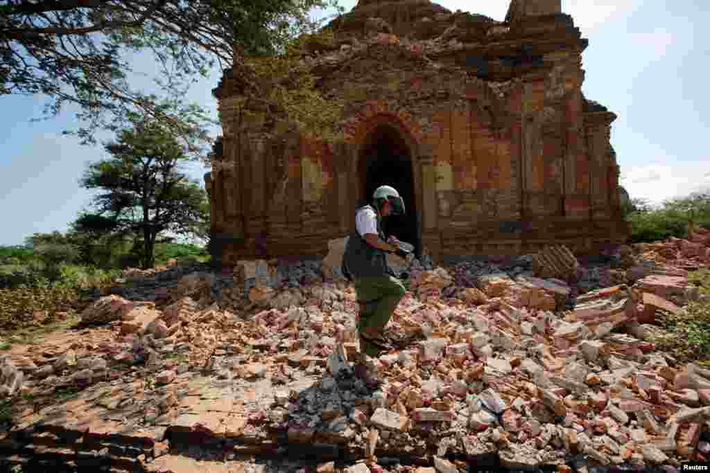 A photographer walks outside a collapsed pagoda after an earthquake in Bagan, Myanmar, Aug. 25, 2016.