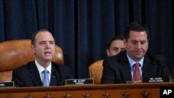 The moon shines through clouds over the White House in Washington, late Tuesday, Nov. 12, 2019. The public impeachment inquiry hearings are set to begin Wednesday.