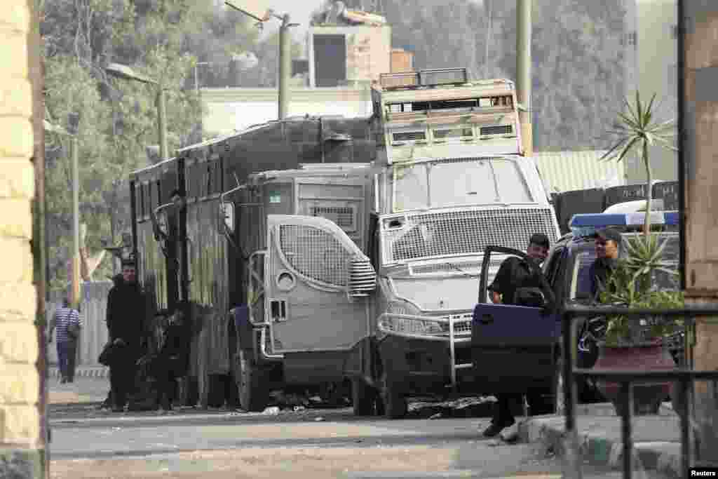 Egyptian police escorts stand by vehicles for general prisoner transport at Tora prison, Cairo, August 22, 2013.