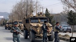 FILE - Foreign security personnel and Afghan police arrive at the site of an attack in Kabul, Afghanistan, March 6, 2020.