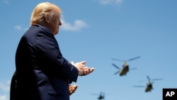 President Donald Trump applauds as Army helicopters fly overÂ during the Class of 2020 at a commencement ceremony on the parade field, at the United States Military Academy in West Point, N.Y., June 13, 2020. 