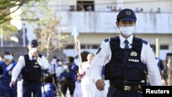 Police officers walk to guard during the Tokyo 2020 Olympic torch relay amid the coronavirus disease (COVID-19) outbreak in Seiyo, Ehime Prefecture, Japan, April 22, 2021. Mandatory credit Kyodo/via REUTERS ATTENTION EDITORS - THIS IMAGE HAS BEEN SUPPLI