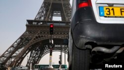 Sebuah mobil melintas dekat Menara Eiffel di Paris (14/3).