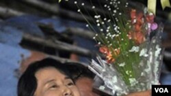 Tokoh oposisi Birma, Aung San Suu Kyi, menerima karangan bunga dari seorang pendukungnya setelah bebas dari tahanan rumah akhir pekan ini.