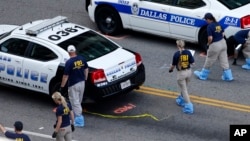 An FBI evidence response team works the crime scene, July 10, 2016, where five Dallas police officers were killed Thursday, in Dallas.