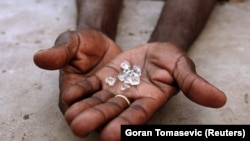 FILE PHOTO: An illegal diamond dealer from Zimbabwe displays diamonds for sale in Manica, near the border with Zimbabwe, September 19, 2010. REUTERS/Goran Tomasevic/File Photo