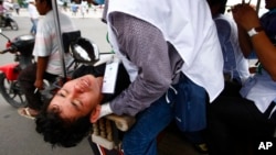 បាតុករ​គណបក្ស​ប្រឆាំង​មួយ​រូប​ដែល​ត្រូវ​រង​របួស​ត្រូវ​បាន​ដឹក​ទៅ​មន្ទីរពេទ្យ​ជិត​ព្រះបរមរាជវាំង​កាល​ពី​ថ្ងៃ​អាទិត្យ ទី​១៥ ខែ​កញ្ញា ឆ្នាំ​២០១៣។