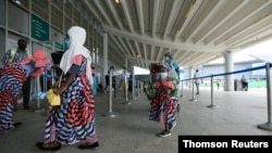 A family is seen in a line at the domestic wing of the Nnamdi Azikiwe International Airport on its reopening day for domestic flight operations, following the coronavirus disease outbreak, in Abuja, Nigeria, July 8, 2020.