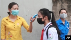 រូបឯកសារ៖ សិស្សម្នាក់ត្រូវបានវ៉ាស់កម្តៅមុនពេលចូលរៀននៅសាលារៀនមួយក្នុងក្រុងហាណូយ ប្រទេសវៀតណាម កាលពីថ្ងៃទី០៤ ខែឧសភា ឆ្នាំ២០២០។ 