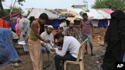 Seorang pegawai Komisi Tinggi PBB untuk Pengungsi (UNHCR) memperbarui catatan untuk pengungsi Rohingya yang tinggal di tempat penampungan sementara di pinggiran Jammu, India, 20 Juni 2017. (Foto: dok).